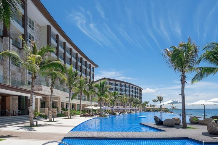 Dusit Thani Mactan Cebu Resort with infinity pool, palm trees, and ocean view.
