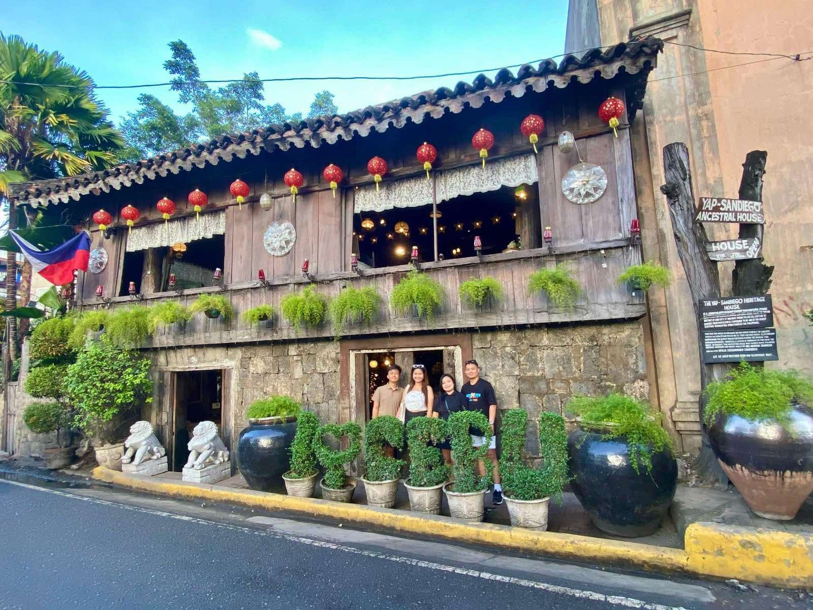 Home A group of travelers posing in front of the Yap-Sandiego Ancestral House in Cebu City, showcasing the historic Spanish-era architecture and heritage sites included in the private cultural tours by Cebu Travel & Oslob Tours.